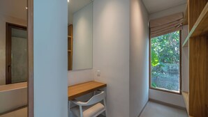 A modern bathroom with a wooden vanity, a large mirror, and a window with a view of greenery. - Dreamscape Haven  (Canggu)