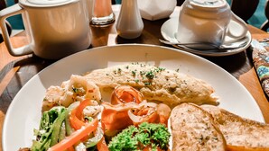 A plate of food with a salad, grilled vegetables, and bread, accompanied by a pitcher of a creamy beverage. - Ari Cottages (Ubud)