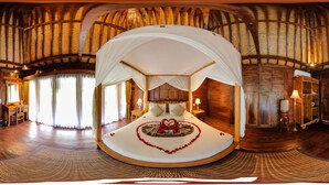 A circular bed with a canopy, wooden walls, and a large window. - Ari Cottages (Ubud)