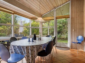 An indoor dining area with a round table, chairs, and a view of the outdoors.