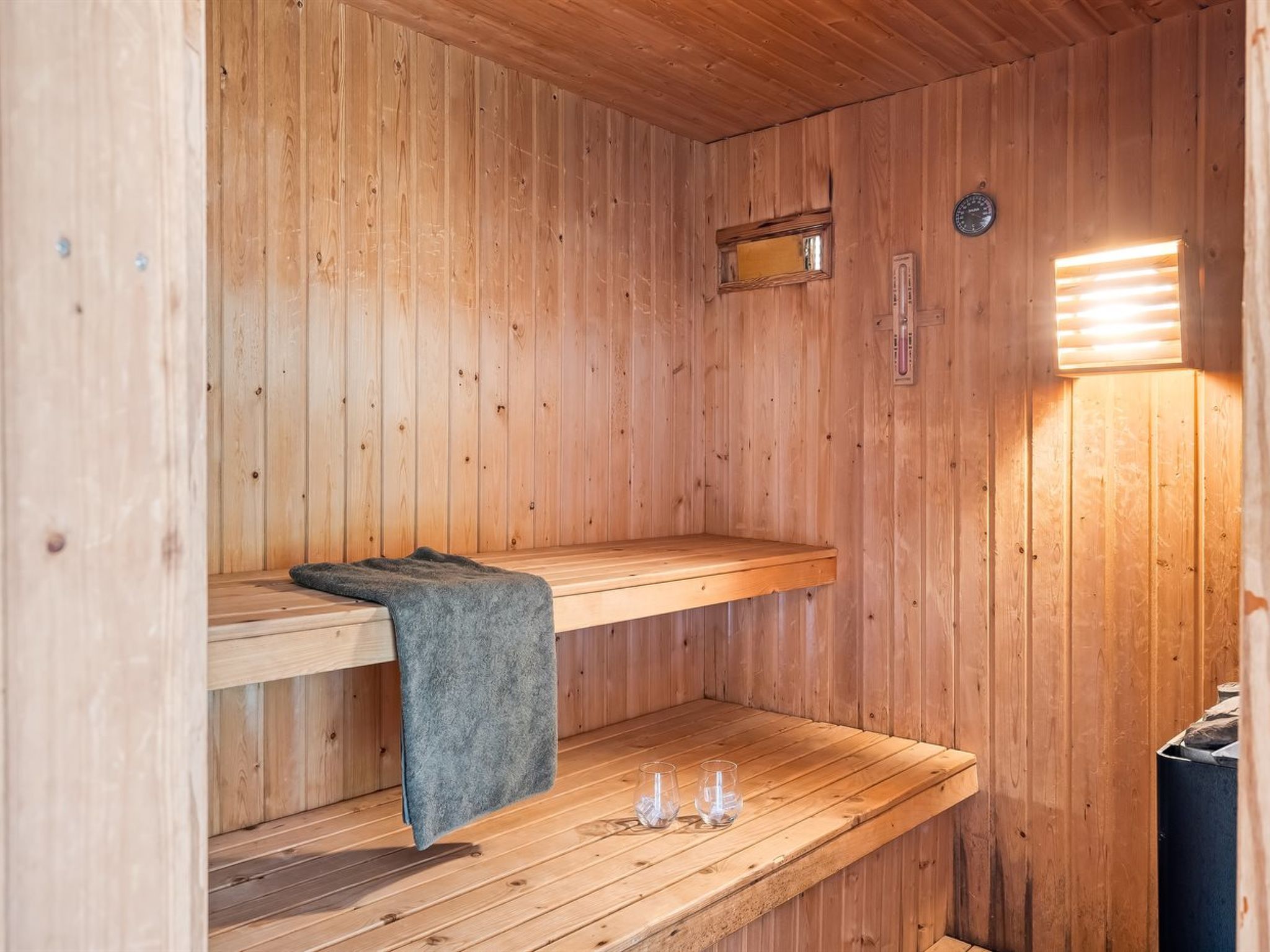 A wooden sauna with benches and a bench with a towel.
