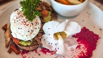 A plate with a salad, a poached egg, and a dollop of sauce.