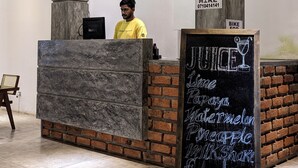 A reception desk with a chalkboard menu listing juices, limes, watermelon, pineapple, milkshakes, and flounda. - Ami Mirissa (Kamburugamuwa)