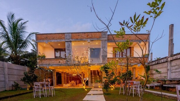 A two-story house with a central staircase, a covered outdoor seating area, and a well-maintained lawn. - Ami Mirissa (Kamburugamuwa)