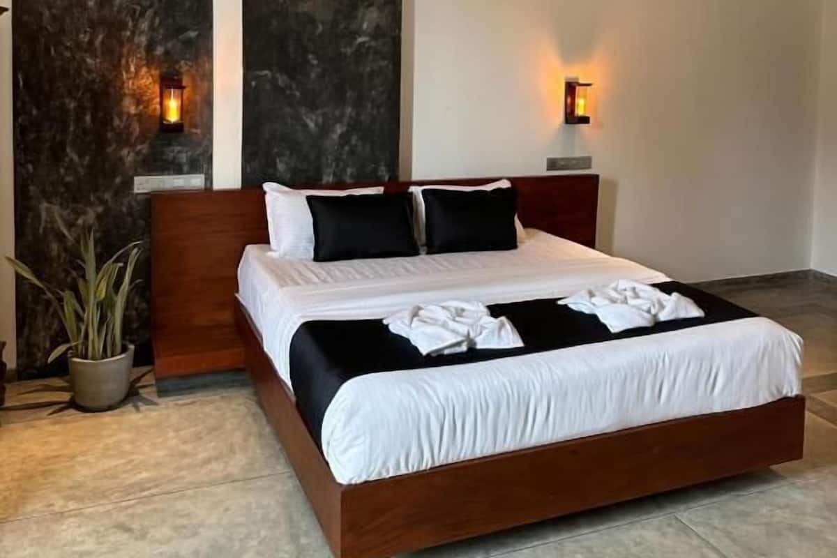 Quarto moderno com uma cama grande, paredes texturizadas escuras e um ventilador de teto.