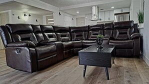 A sectional sofa with a modern design, a wooden coffee table, and a ceiling light fixture. - Contemporary Modern Villa (Las Vegas)