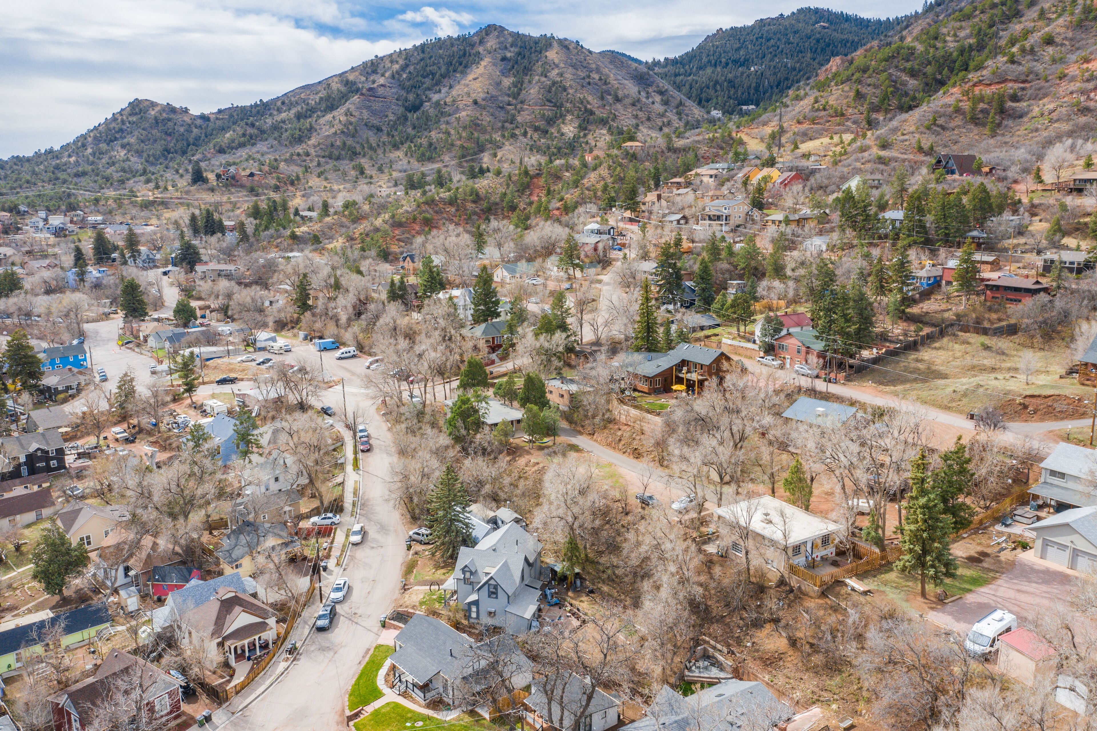 A residential area with houses, roads, and a mountainous backdrop.