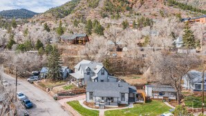 A residential area with houses, a road, and a hilly backdrop. - Granite Grotto (Manitou Springs)
