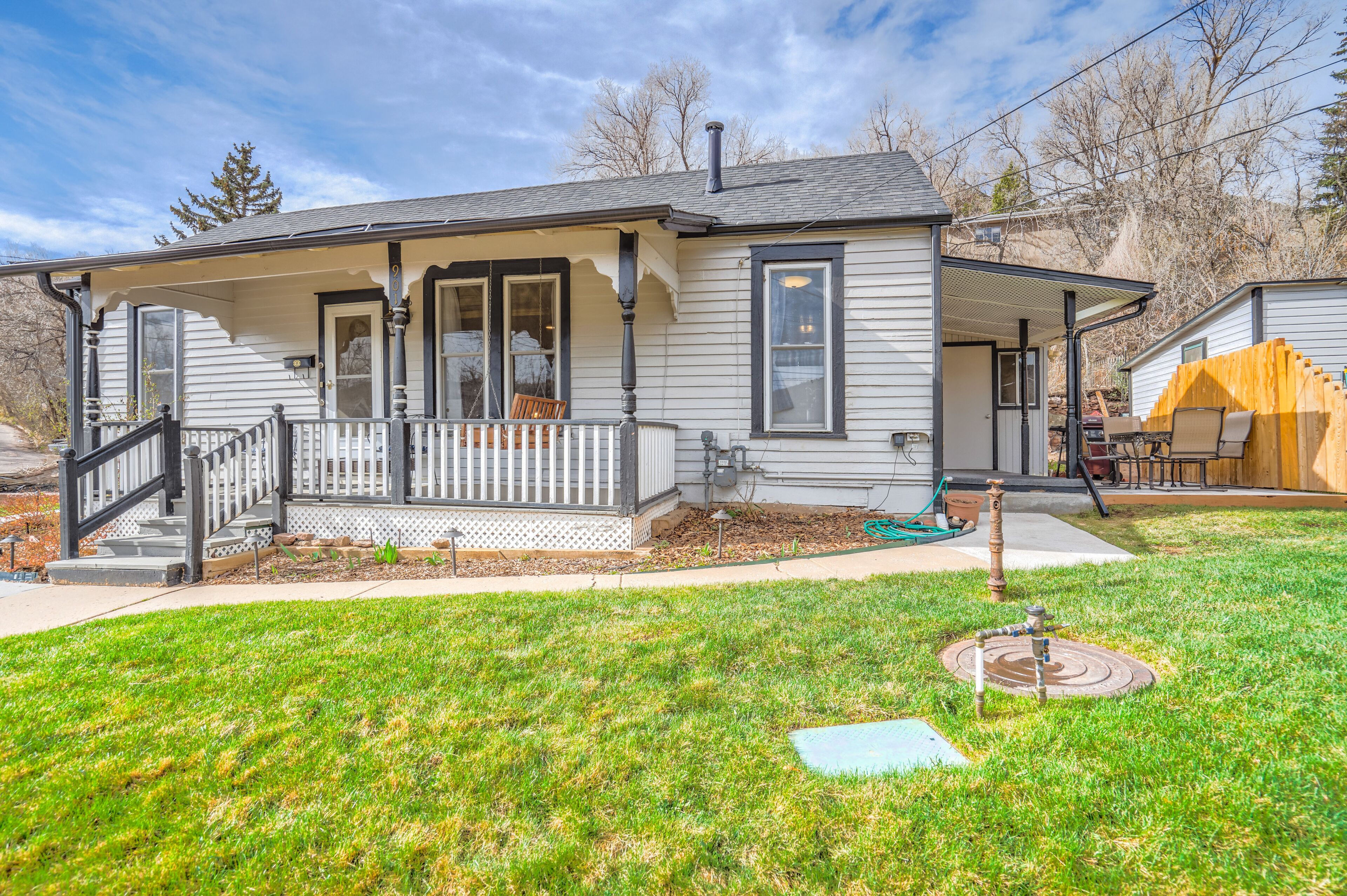 A single-story house with a front porch, a covered patio, and a well-maintained lawn.