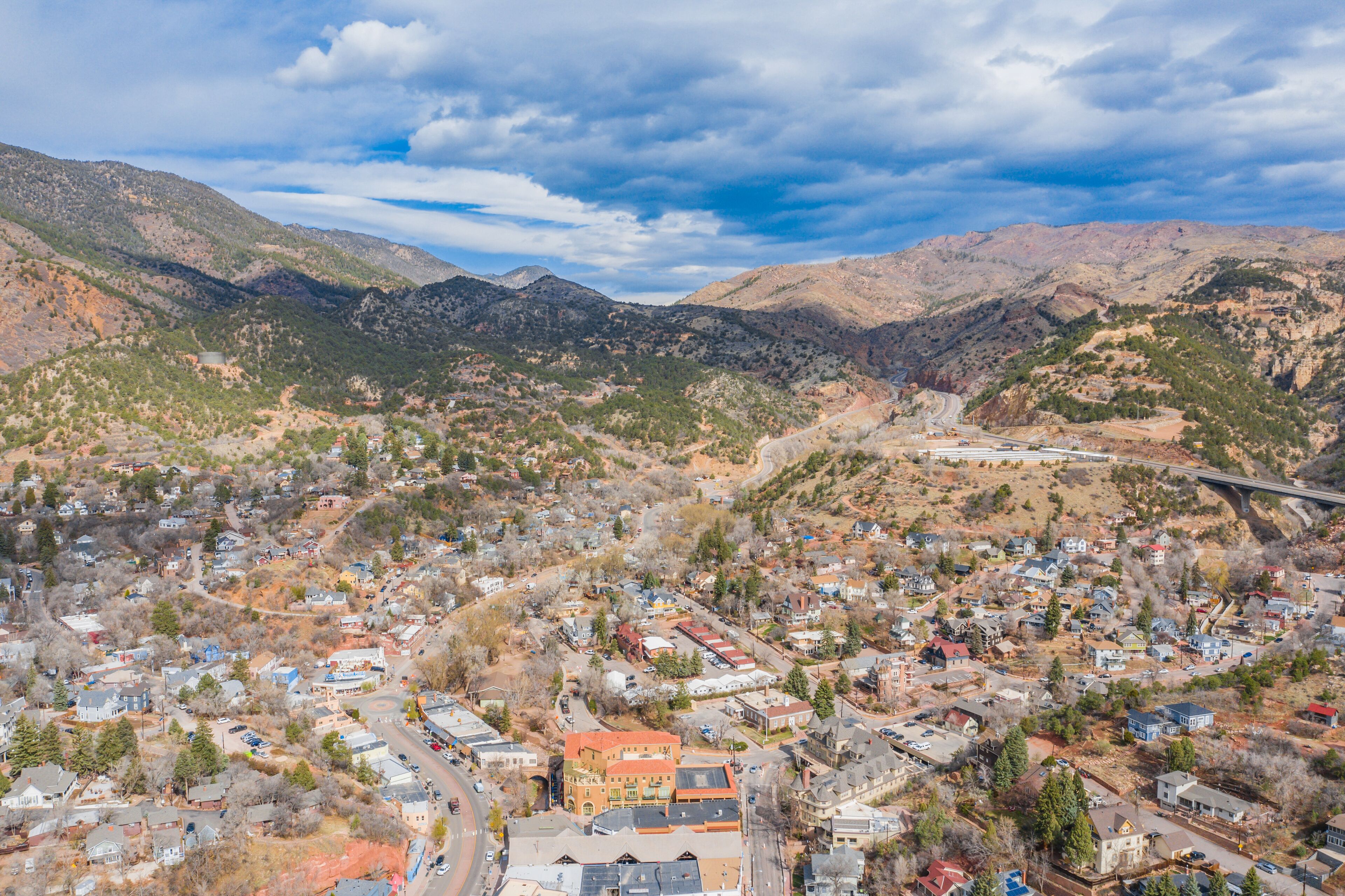 A town nestled in a valley with a bridge in the distance.