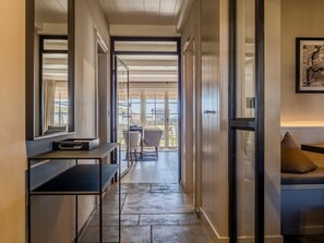 A hallway with a desk, chairs, and a sofa.