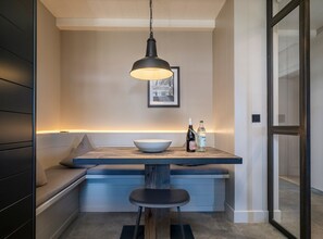 A modern kitchen with a built-in bench and a pendant light above it.