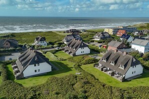 Ein Küstendorf mit traditionellen Häusern, einem Strand und Blick auf das Meer.