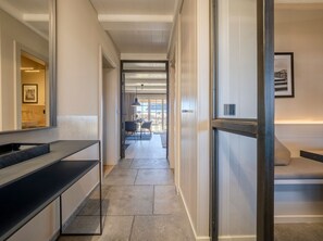 Ein moderner Hotelkorridor mit einer Bank, einer Glastür und einem Essbereich im Hintergrund.