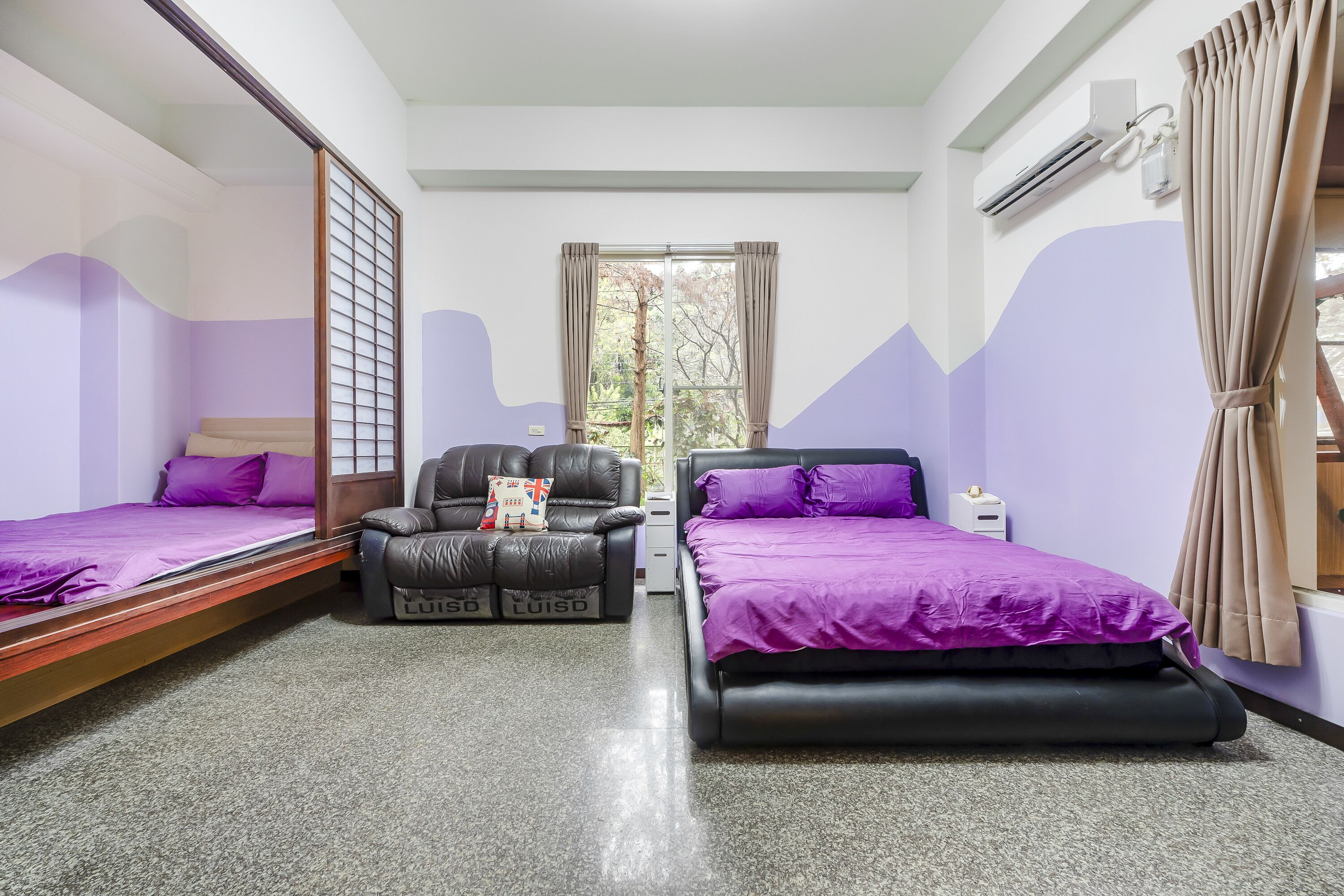 A bedroom with two beds, a sofa, and a window with curtains.