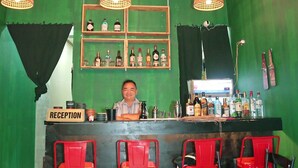 A bar with a reception area, red chairs, and hanging light fixtures. - TUAN CENTRAL HOTEL (Hanoi)