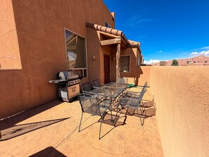 An outdoor patio with a grill and metal chairs. - Rim Vistas - 4A4 (Moab)