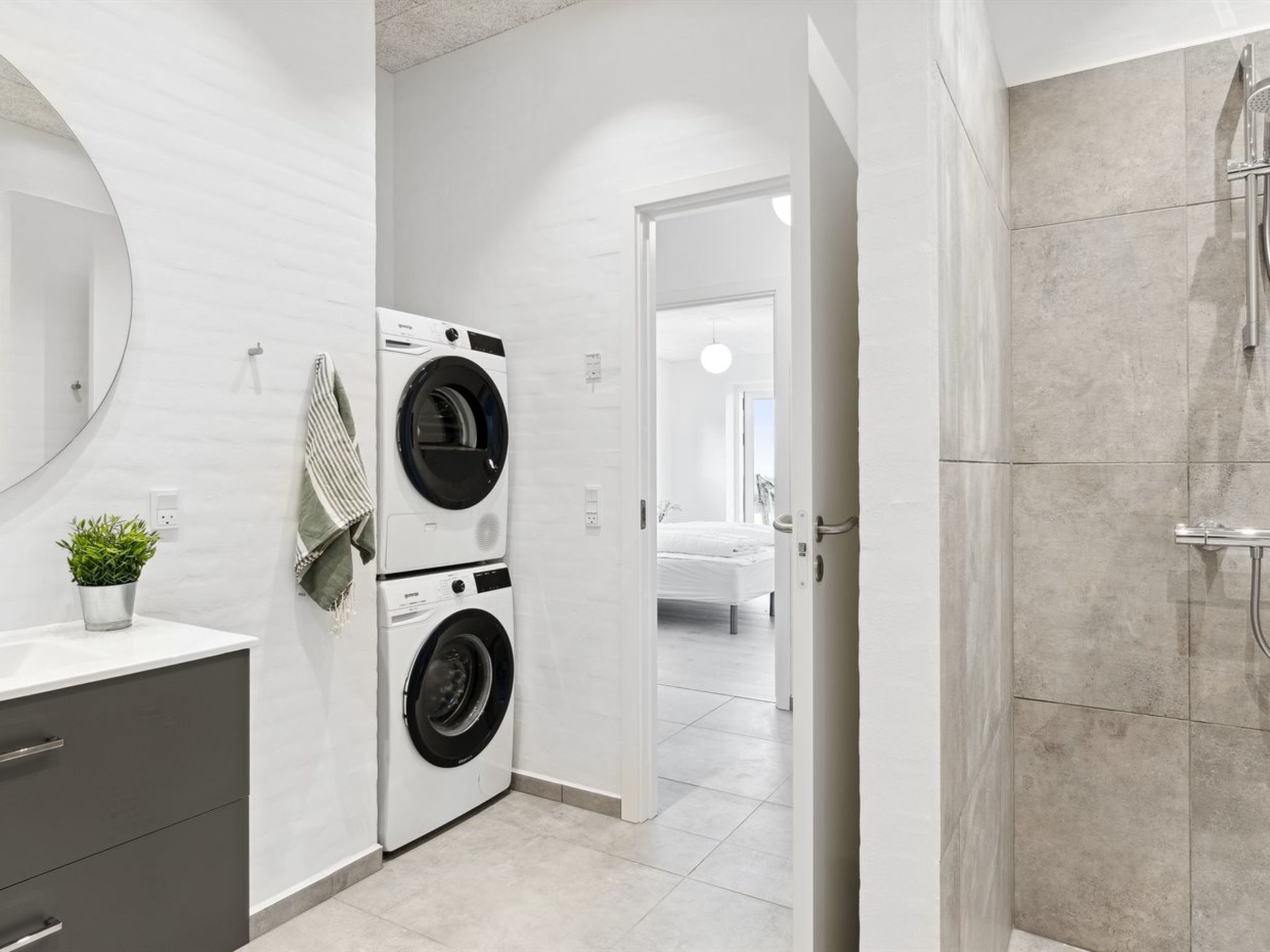 Un bagno moderno con doccia, lavatrice e WC.