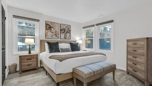 A bedroom with a bed, bedside tables, a bench, and a dresser. - Downtown 2BD Retreat-Walk Everywhere! (Park City)