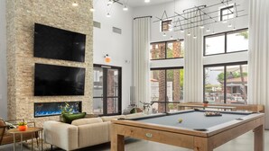 A modern indoor pool area with a pool table, comfortable seating, and large windows offering views of the outdoors. - TWO Glendale CozySuites with Pool 2 & 9 (Glendale)