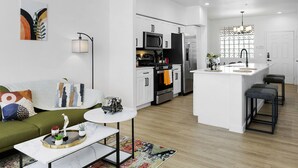 A modern kitchen with white cabinetry, stainless steel appliances, and a central island. - TWO Glendale CozySuites with Pool 2 & 9 (Glendale)