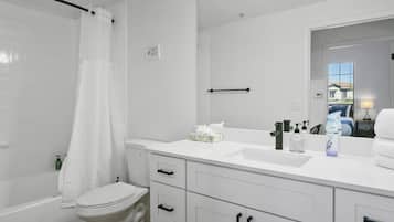 A modern bathroom with a white sink, toilet, and bathtub.