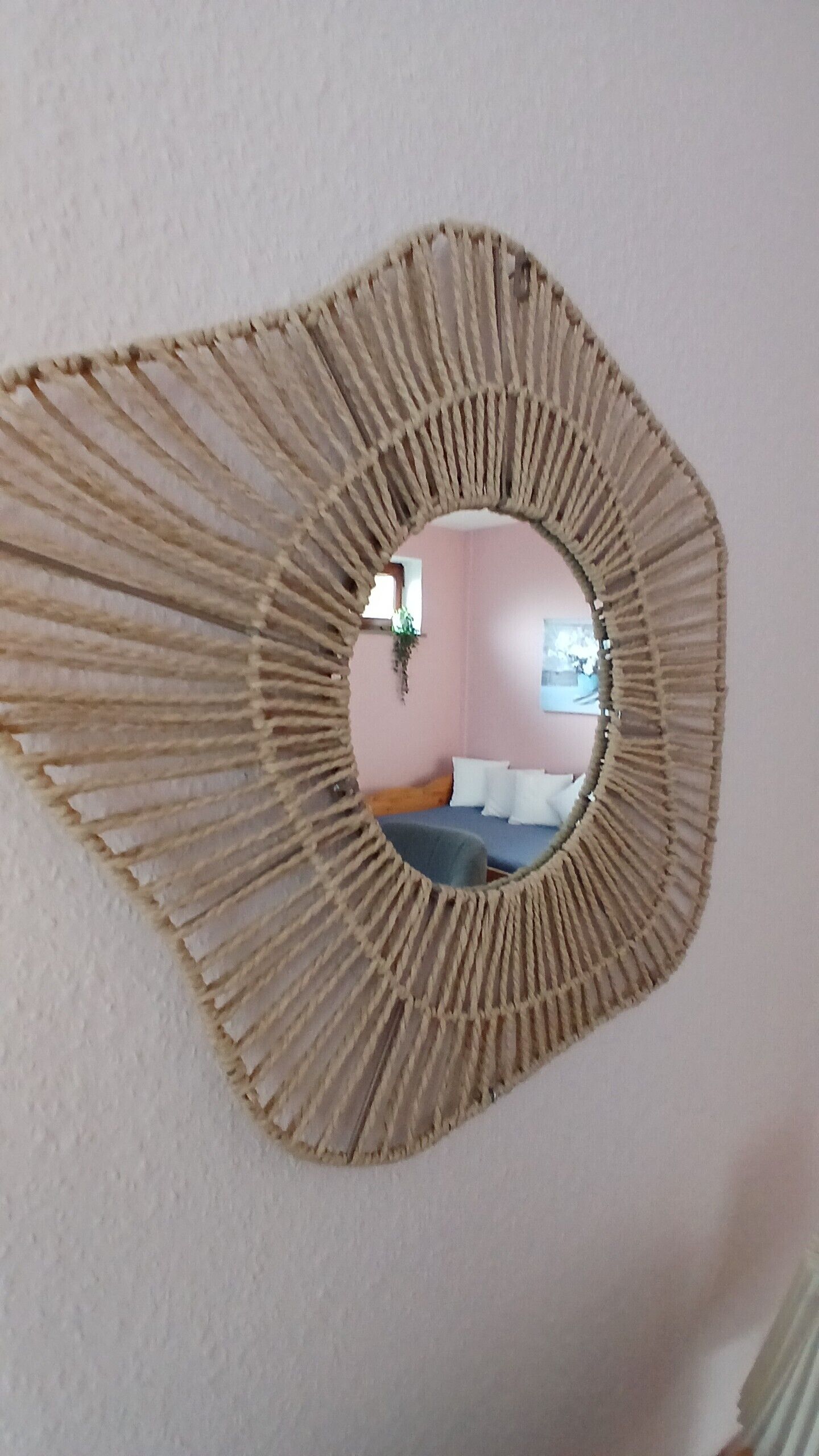 Un miroir rond, doté d’un cadre à motifs, fixé au mur.