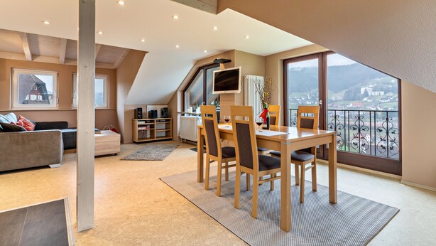 Un apartament modern amb zona de dinar, cuina i un balcó amb vistes.