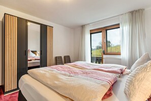 Une chambre à coucher avec un lit, une armoire, une fenêtre et une vue sur l’extérieur.