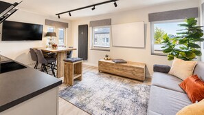 Un espacio habitable moderno con cocina, una mesa de comedor y un sofá.
