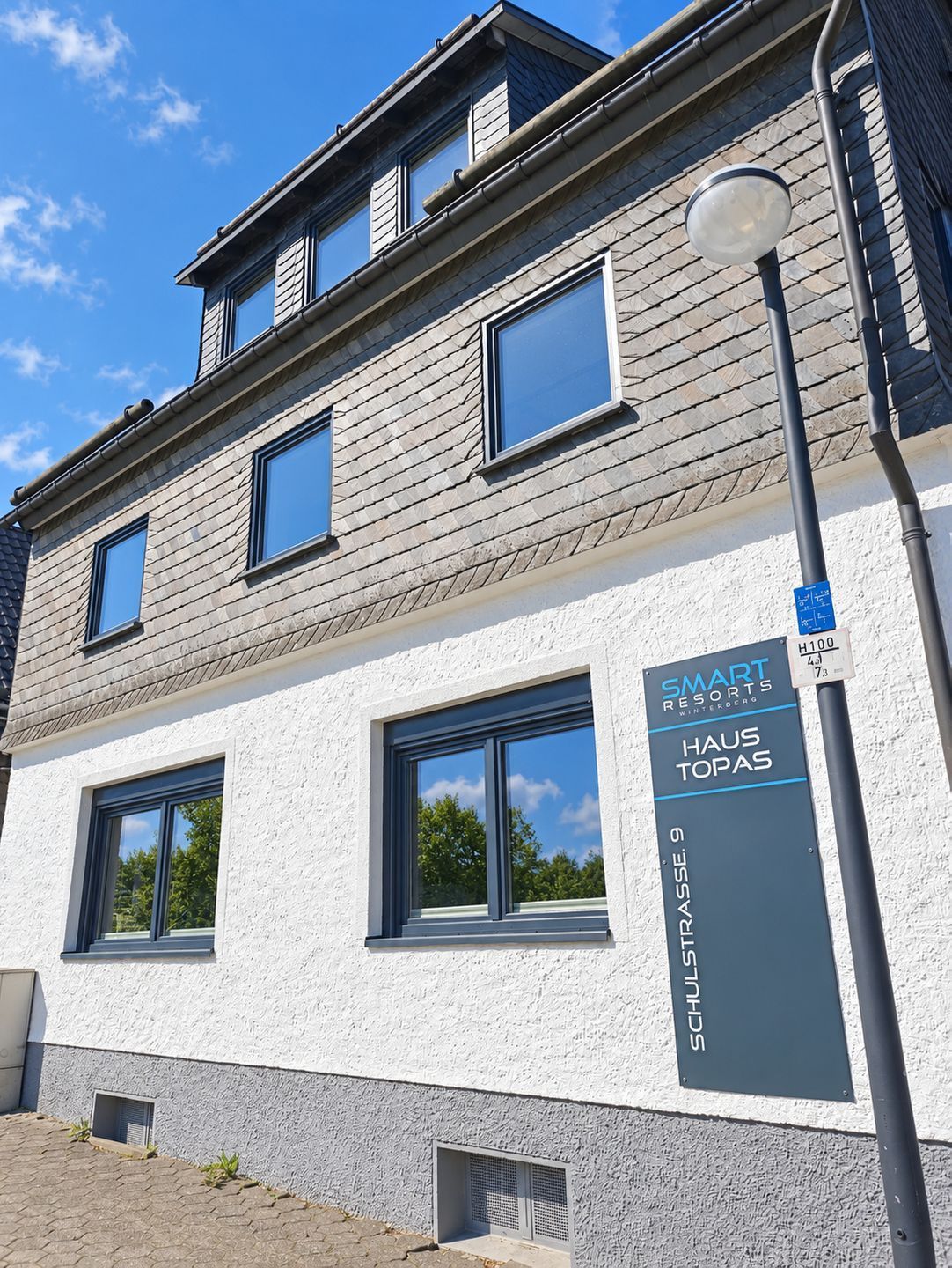 A building with a sign for 'Smart Resorts Haus Topas' and 'Schulstrasse 9'.