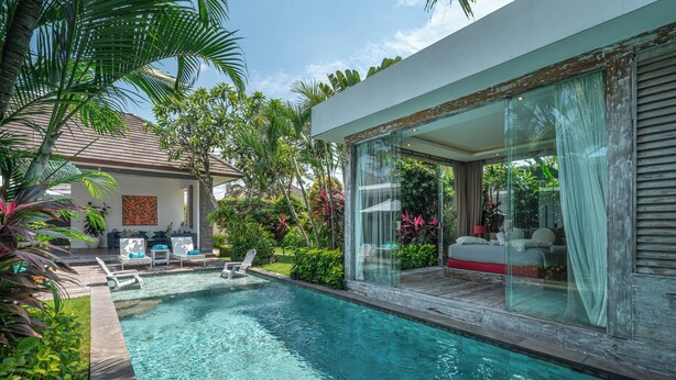 Ein modernes Haus mit Swimmingpool, Außensitzgelegenheiten und üppiger Bepflanzung.
