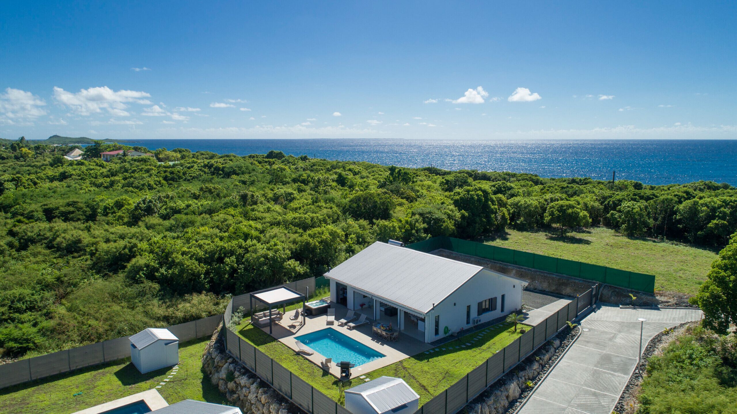 Luxury villa in the West Indies: Exceptional aerial view with swimming pool, sea and tropical vegetation