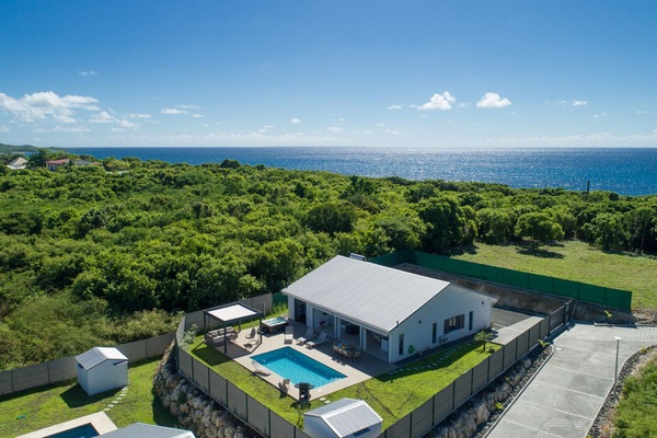 Luxury villa in the West Indies: Exceptional aerial view with swimming pool, sea and tropical vegetation