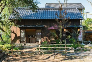 A traditional Japanese building with a tiled roof, wooden exterior, and a small entrance.