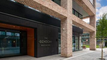 The Benson Building with a modern brick facade, large glass windows, and a visible entrance.