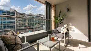 A balcony with a sofa, a coffee table, and a potted plant. - The Benson Two by Dublin At Home (Dublin)