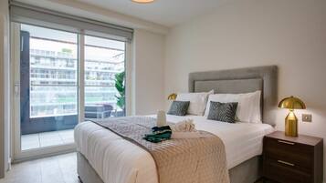 A bedroom with a bed, bedside table, and a view through a sliding door.