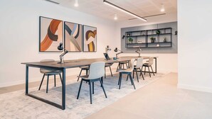 A modern office space with a long table, multiple chairs, and three abstract paintings on the wall. - City Apartments by Dublin At Home Two (Dublin 1)
