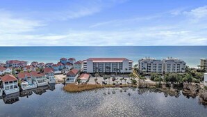 A coastal resort with multiple buildings, a marina, and a view of the ocean. - Huntington By the Sea 501 (Miramar Bch)