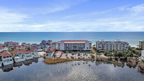 A coastal resort with multiple buildings, a marina, and a view of the ocean.