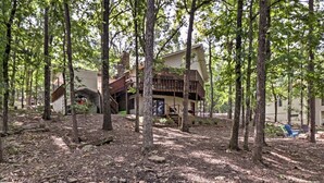 Une cabane dotée d’une terrasse, entourée d’arbres.