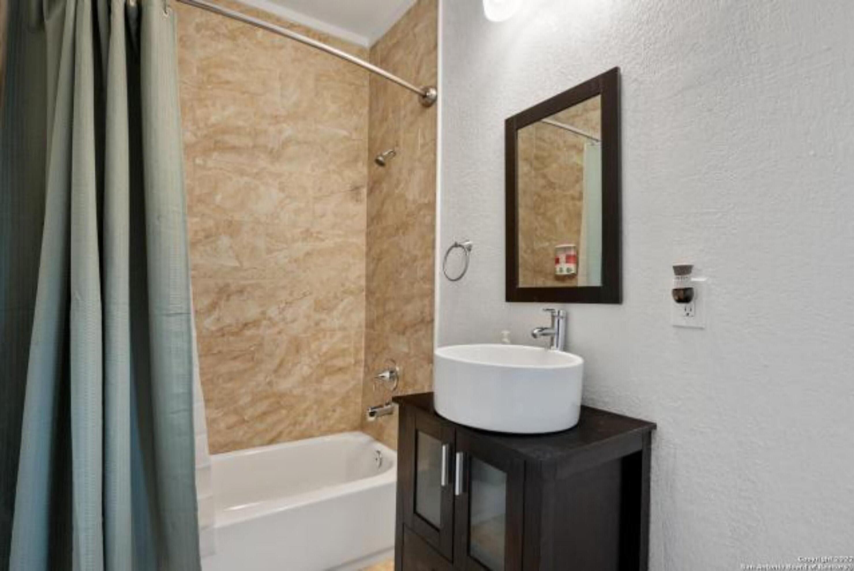 Un bany amb banyera, un lavabo i un mirall a la paret.