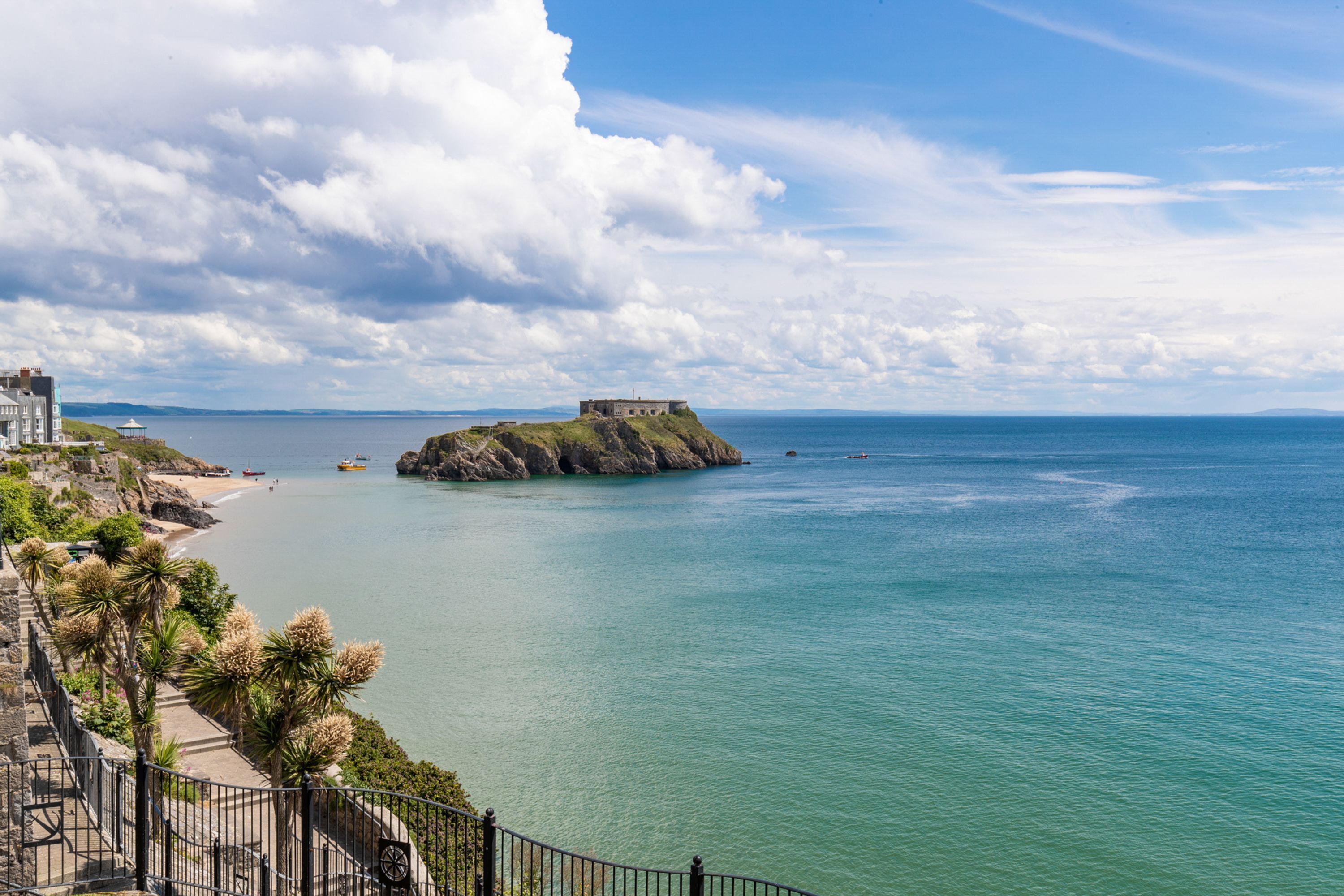 A coastal view with a fort on a small island, clear skies, and calm sea.