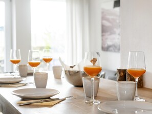 A breakfast table set with plates, glasses, and a bowl.