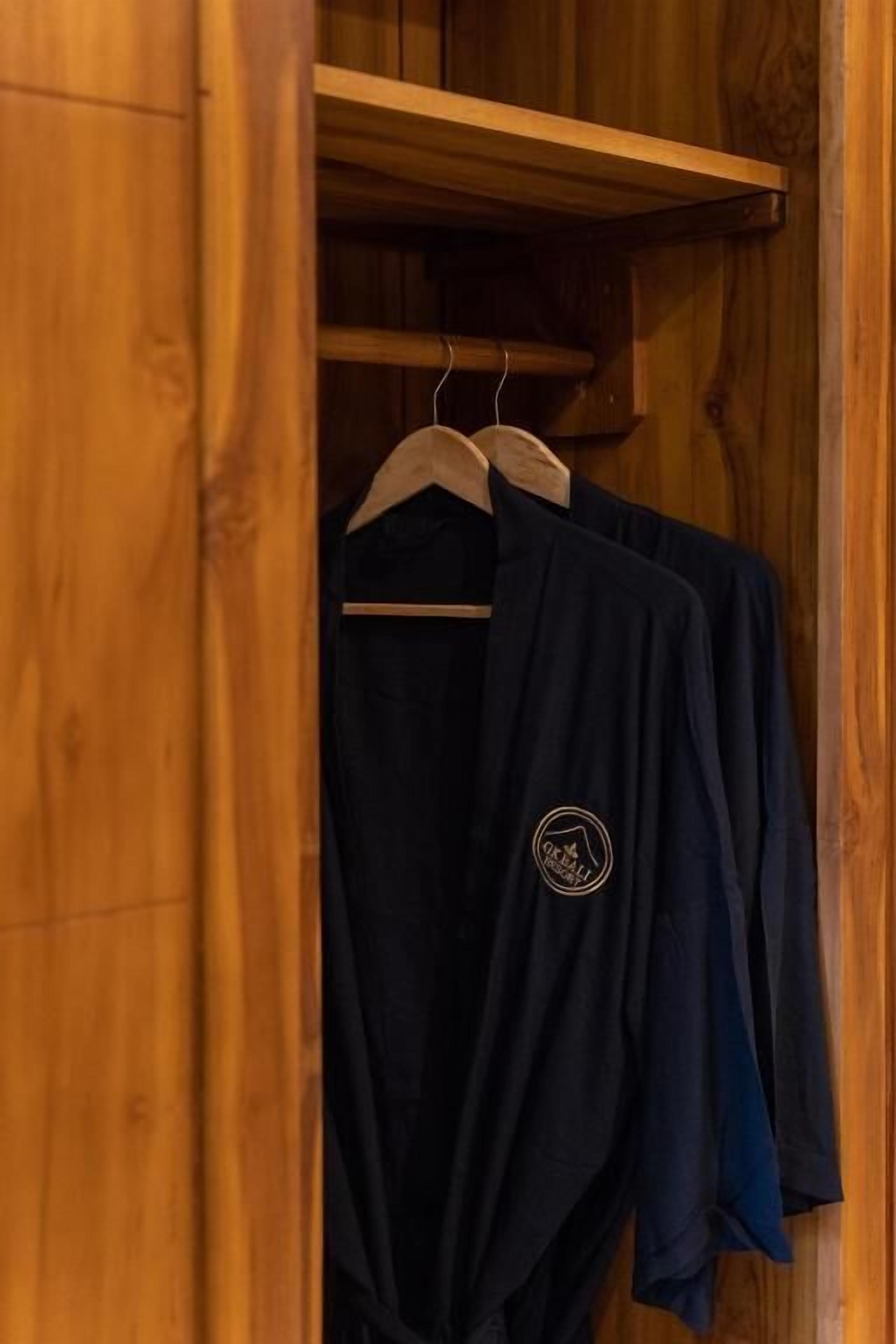 A wooden wardrobe with a hanging rod inside.