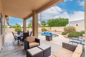 A covered patio with outdoor furniture, a pool, and a view of the surrounding landscape. - NEW! Luxury, Scottsdale Getaway! (Scottsdale)