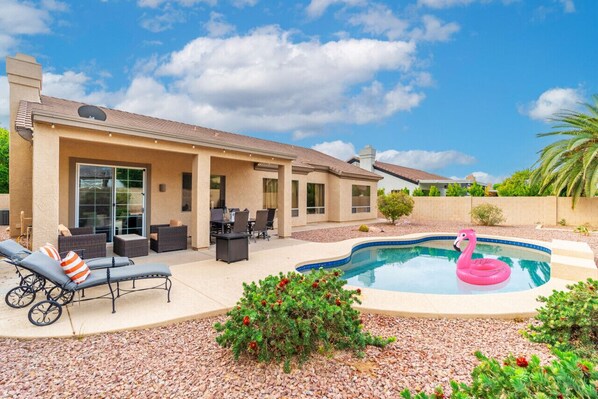 A house with a swimming pool, outdoor furniture, and a well-maintained garden.