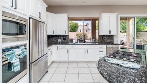 A modern kitchen with white cabinets, stainless steel appliances, and a granite countertop. - NEW! Luxury, Scottsdale Getaway! (Scottsdale)