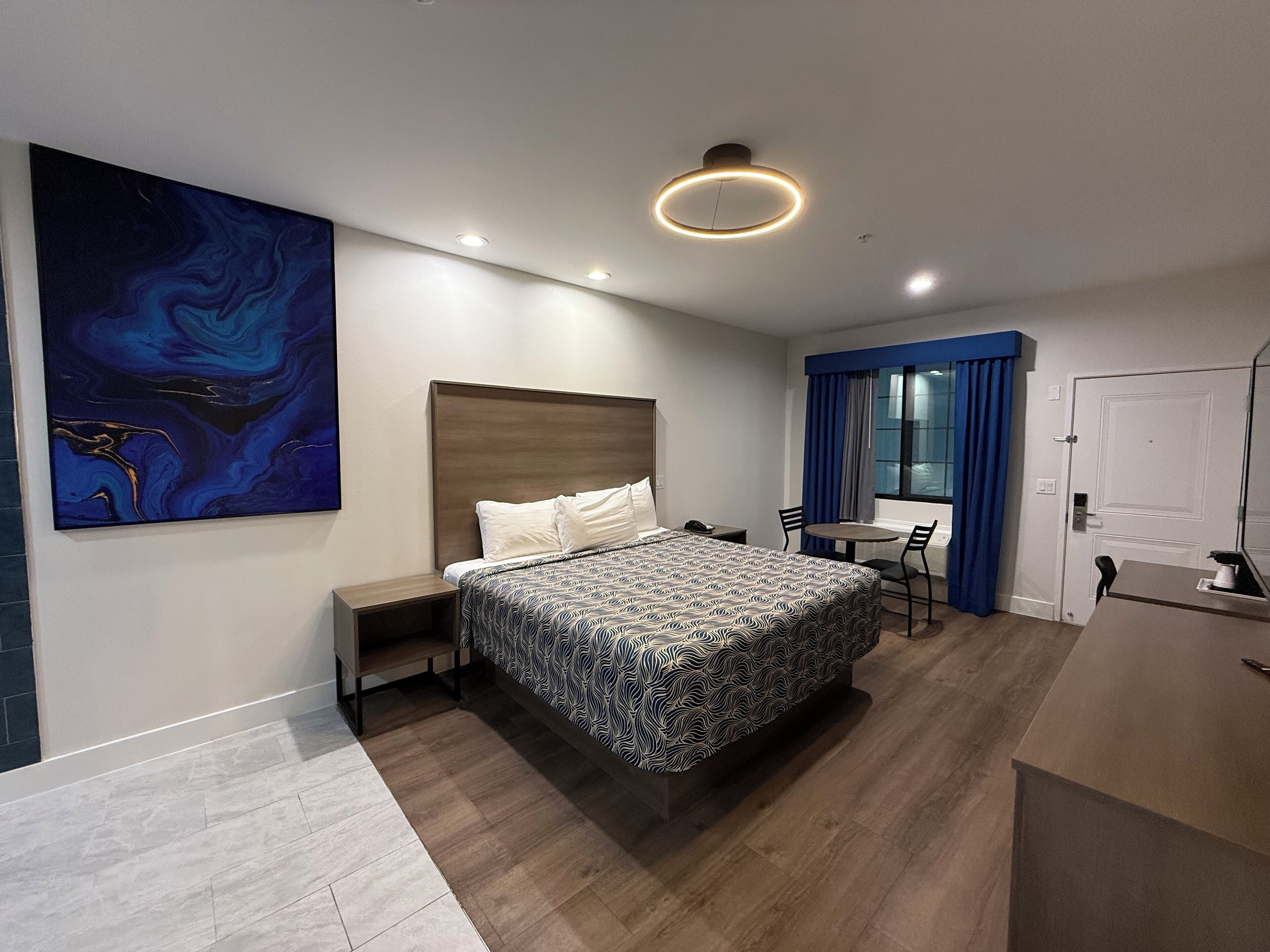 Een moderne hotelkamer met een groot bed, een bureau en een stoel.